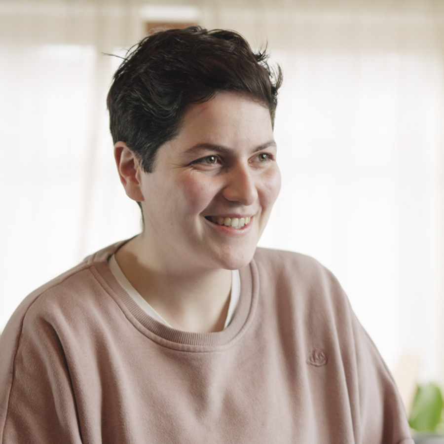 Portraitfoto von Ellen, Transmann und Hochzeitsvideograf aus Baden-Württemberg – im Interviewsetup. Kreativer Filmemacher mit Fokus auf emotionale Hochzeitsvideos.