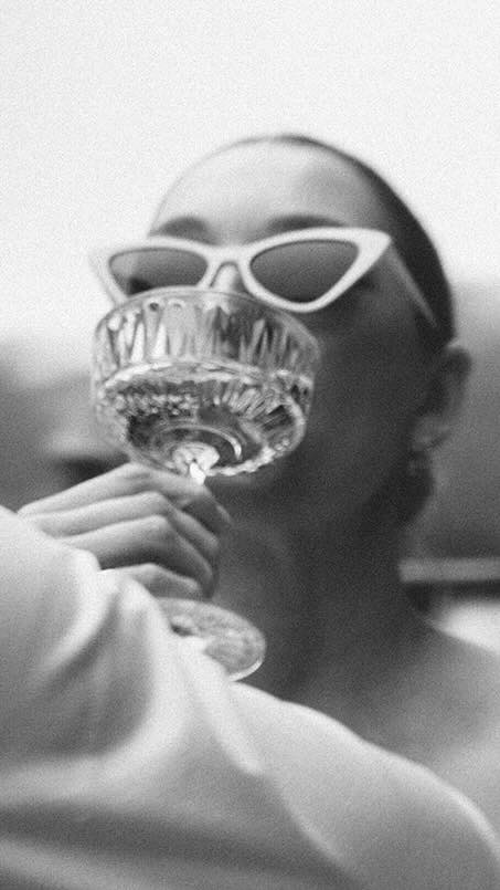 Braut mit Sonnenbrille, trinkt aus einem edlen Glas, Fokus auf Glas und Lippen, Champagner, Sekt – festgehalten Hochzeitsfilm Stuttgart